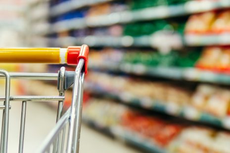 Shopping cart in supermarket. Part of shopping trolley in supermarket aisle. Reimagining land use systems through the consumer